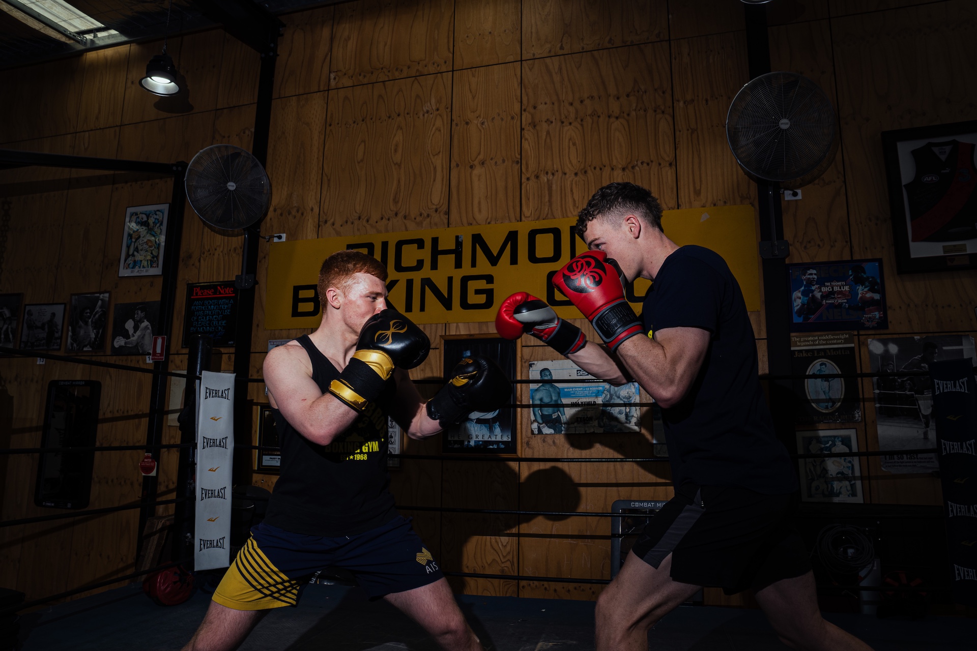 Two boxers sparring in front of the Richmond Boxing Club sign